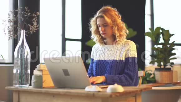 年轻的自由职业者游戏玩家欧洲可爱的女孩使用她的笔记本电脑在阁楼舒适的工作空间概念画像视频的预览图