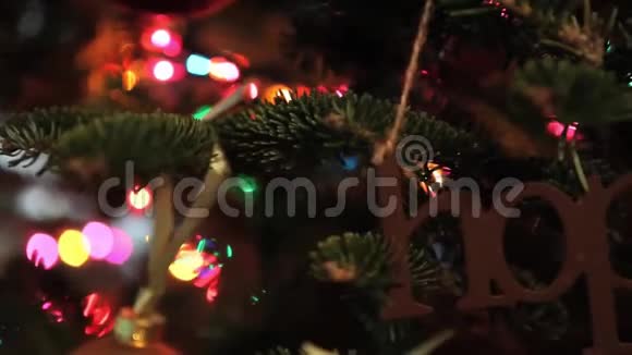 圣诞装饰在圣诞树上用锡纸和照明在闪烁的背景上签名视频的预览图