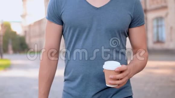 英俊的男人走在户外喝茶视频的预览图