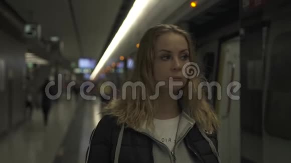 年轻女子在地铁站站台等车地下旅行的年轻女子现代城市地铁里的女孩视频的预览图