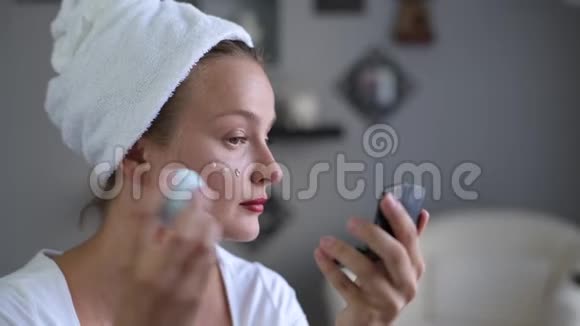 美丽的女人完美光滑的健康皮肤应用面部基础视频的预览图