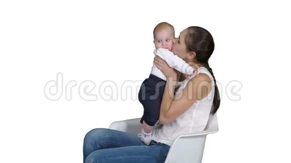 妈妈和可爱的宝宝坐在白色背景的椅子上视频的预览图