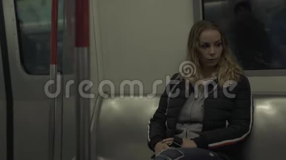 坐地铁火车的年轻女子坐在地下地铁车厢上的旅行者女人现代城市的女孩视频的预览图
