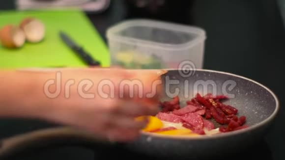 有人在平底锅上用香肠煮煎蛋破壳视频的预览图