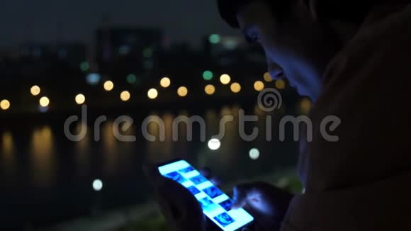 夜间在莫斯科市使用手机的年轻人使用bokeh灯视频的预览图