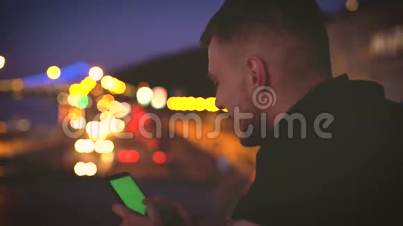 概念特写照片年轻人使用他的智能手机绿色屏幕彩色在高速公路城市灯光城市视频的预览图