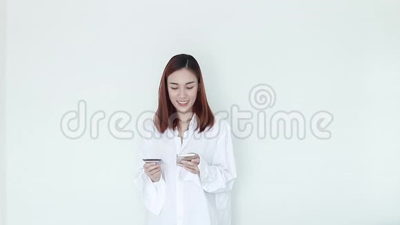 性感女人穿着白色睡衣用手机支付网上购物的信用卡视频的预览图