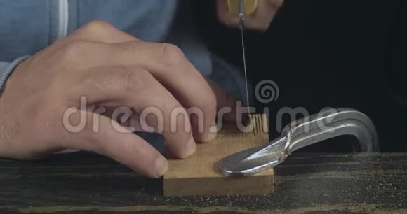 玛娜的特写用手锯锯木的细节木匠做手工木制梳子电影4K录像视频的预览图