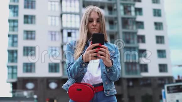 带着时髦太阳镜的微笑卷发少女的概念肖像走在市中心街道上使用视频的预览图