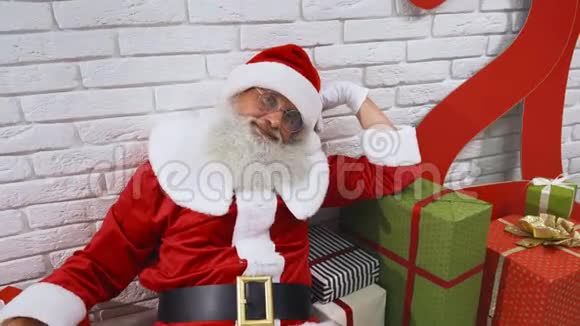 圣诞老人躺在礼物地板上的白色工作室视频的预览图