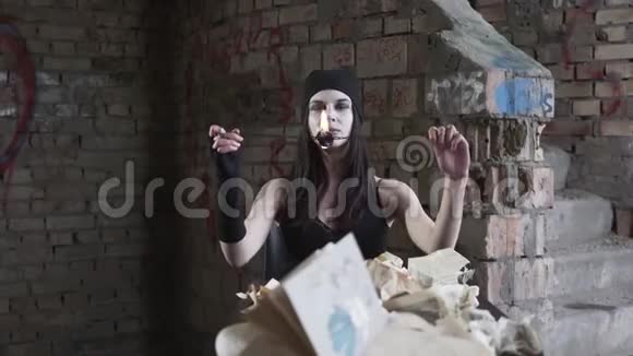 肖像年轻女子白脸吹灭了墙前废弃建筑中的火你的表演视频的预览图