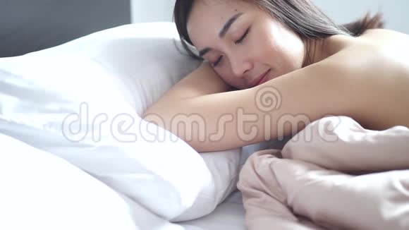 女人不穿衬衫毯子布在床上醒来后灿烂地微笑视频的预览图