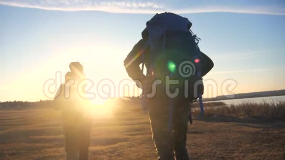 两位游客一起背着背包慢动作走着在阳光的照射下剪影生活方式视频的预览图