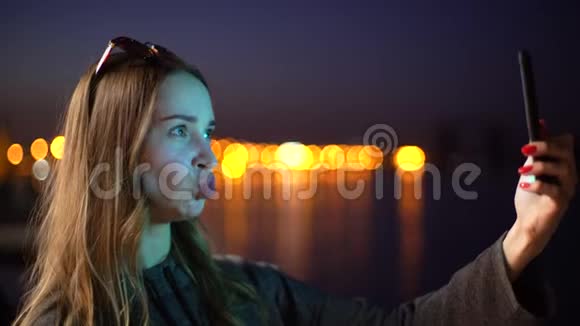 一个年轻的女孩做鬼脸鸭子做海绵在手机的镜头里在手机的背景下什么视频的预览图