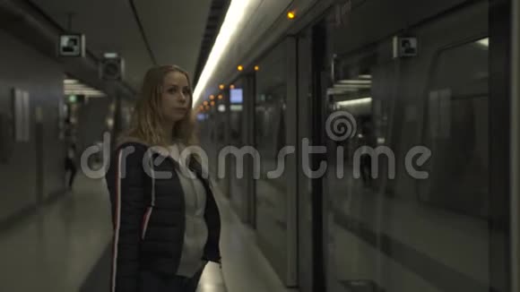 城市妇女在地铁站站台等车地下旅行的年轻女子穿现代服装的女孩城市视频的预览图