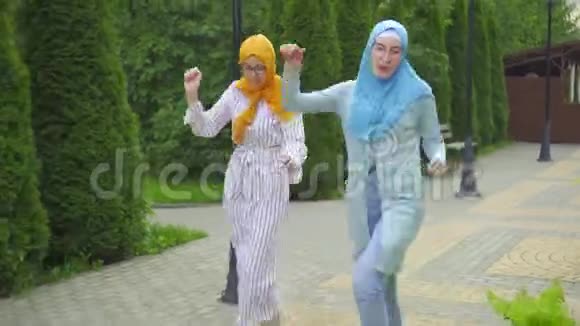 两名积极的穆斯林青年妇女在公园跳舞视频的预览图