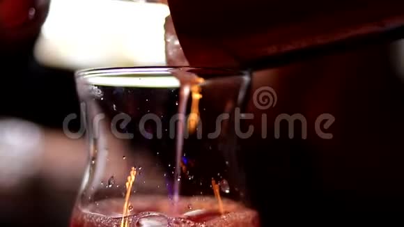 酒保在酒吧的玻璃杯里倒一杯加冰的鸡尾酒视频的预览图