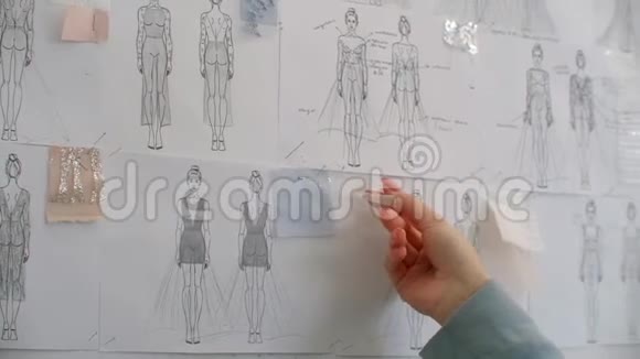 女时装设计师看着被钉在办公桌后面墙上的图纸和素描阳光工作室视频的预览图
