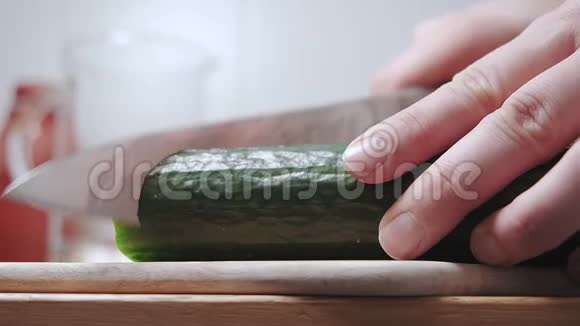 特写女人在木切割板上切黄瓜慢动作视频的预览图