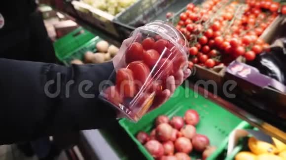 新鲜的有机番茄在一个年轻的女孩手中选择农产品在当地的超市视频的预览图