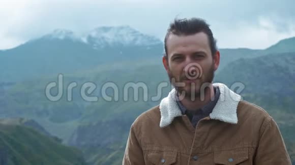 男旅行者摄影师为博客制作专业的山景图片一个留着长发和胡子的人视频的预览图