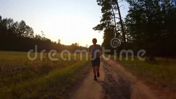 日落时分穿着短裤和蓝色眼镜的女孩在乡间小路上奔跑视频的预览图