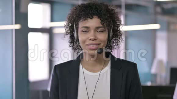 欢快的非洲女商人听头电话的肖像视频的预览图