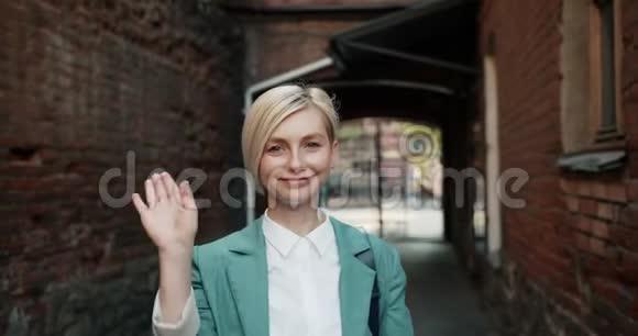 慢镜头肖像美丽的女人挥着手在户外打招呼视频的预览图