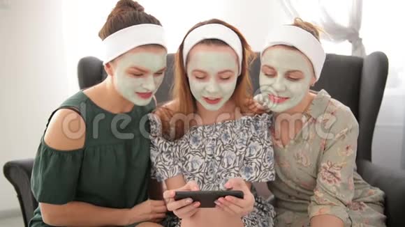 一群女孩花时间在温泉度假村年轻的女士有很多有趣的检查自拍智能手机视频的预览图