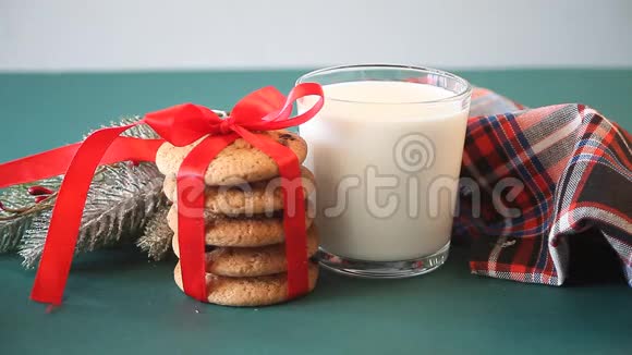 圣诞老人的圣诞饼干女人手在牛奶饼干松枝和餐巾纸的玻璃旁边放了一条短信给圣诞老人视频的预览图