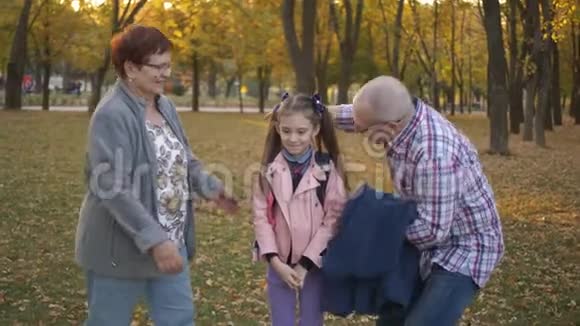 祖父母在秋天公园拥抱孙女视频的预览图