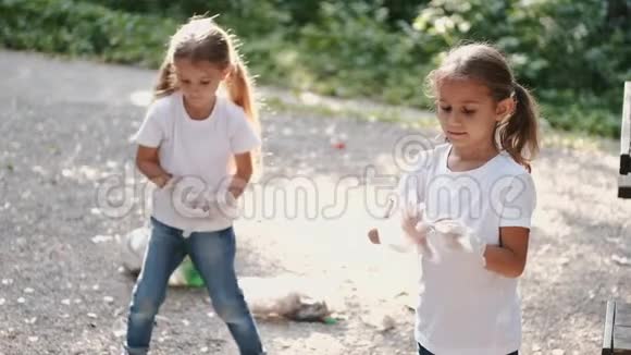 两个小女孩一起在森林里收集垃圾视频的预览图