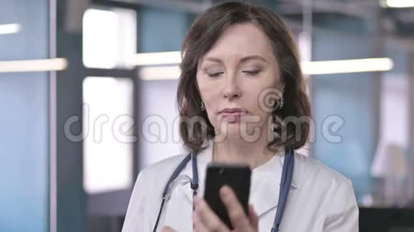职业中年医生在智能电话上微笑与交谈的画像视频的预览图