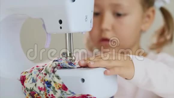 一个小女孩在缝纫布料手和缝纫机的焦点特写镜头视频的预览图