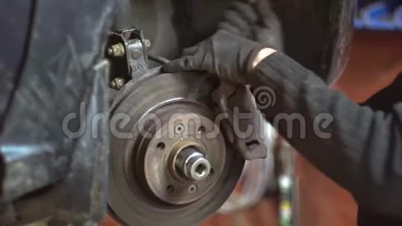 在汽车修理厂修理一辆汽车的一名修理工视频的预览图