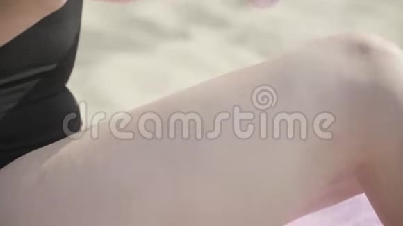 在海滩特写镜头上女性用手在她的腿上涂上太阳喷雾夏日休闲身体护理视频的预览图