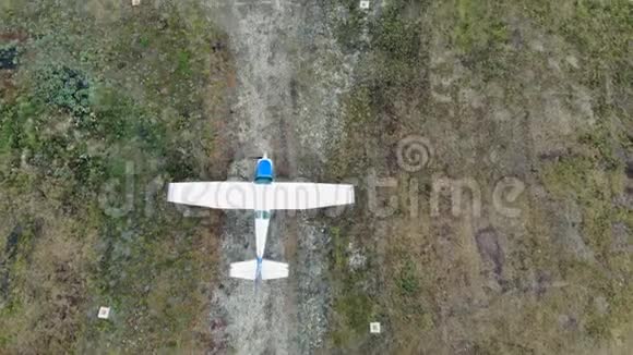 一架小型飞机沿着道路缓慢行驶的俯视图视频的预览图
