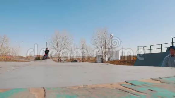 一个穿着灰色连帽衫的bmx骑手骑在溜冰场上打开方向盘视频的预览图