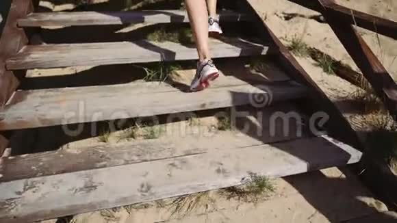 女孩跑步者从码头爬上木制楼梯跑步运动员在楼梯上跑步视频的预览图