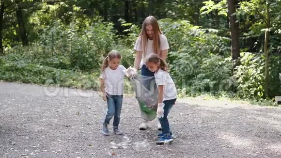 女人和两个小女孩在森林里收集垃圾视频的预览图