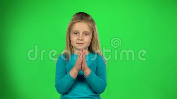 小女孩拍拍手在绿色背景下玩得开心视频的预览图