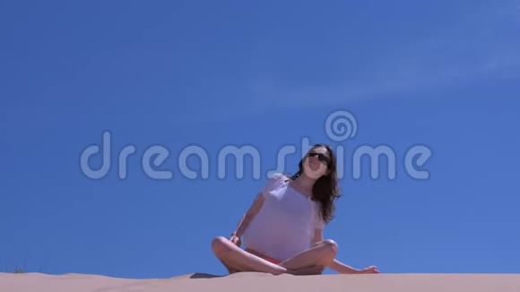 女子伸展坐莲姿沙滩倾斜在侧瑜伽练风天视频的预览图