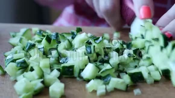 木质厨房板上的小片多汁的绿色和成熟黄瓜视频的预览图