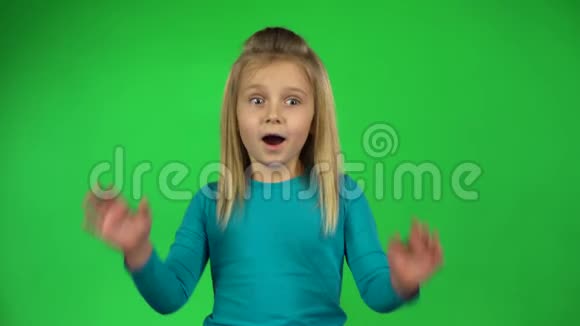 有趣的儿童姿势显示了恐惧的情绪在绿色背景4k视频的预览图