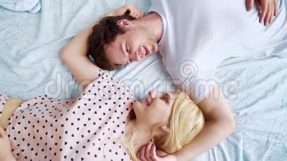 一对浪漫的情侣在早晨面对面地躺在床上视频的预览图