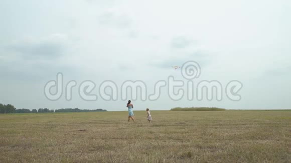 母亲和女儿在田野里唱着风筝视频的预览图
