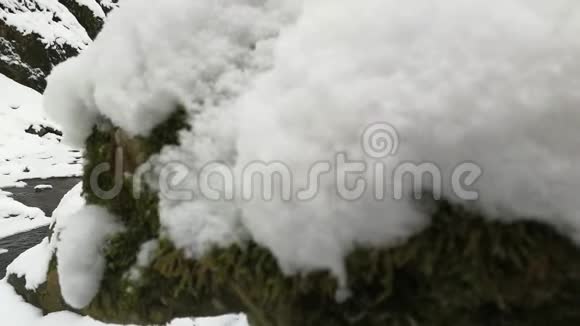 冬天的急流穿过覆盖着积雪的岩石视频的预览图