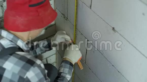 工人用夹钳在混凝土砌块墙上固定金属钢轨的高角镜头视频的预览图