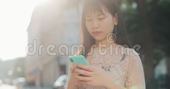 亚洲女孩在阳光下使用电话视频的预览图