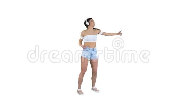 白人女性模特戴着耳机跳跃在白色背景下表达着听音乐的快乐情绪视频的预览图